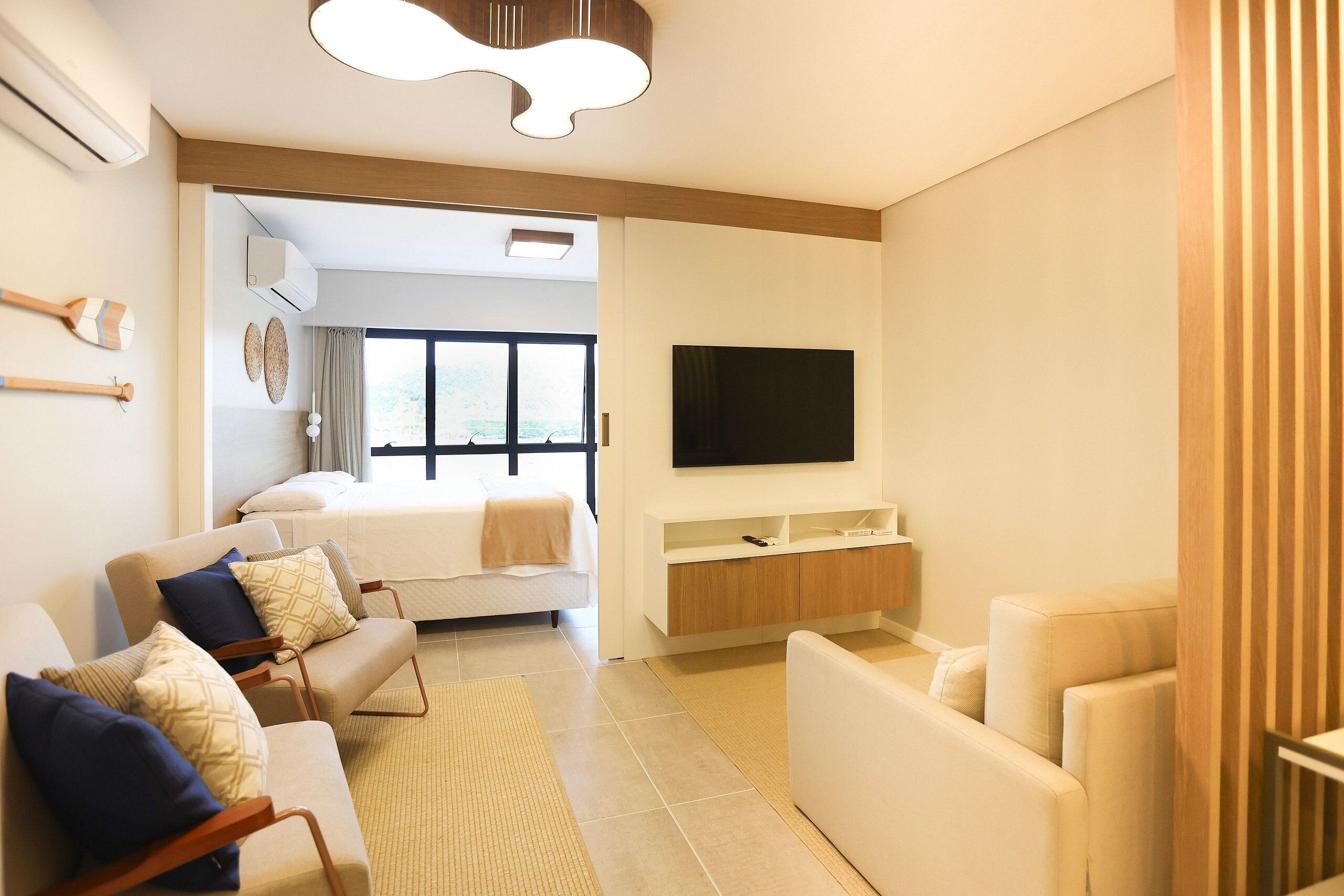 Una sala de estar moderna con un sofá, una mesa de centro y un televisor montado en la pared.