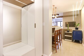 A modern kitchen with a dining area, featuring a wooden dining table, chairs, and a blue cabinet. - Studio Shopping OKA Floripa - SOK108 (Florianopolis)