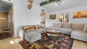 A living room with a sofa, a coffee table, and a rug.