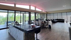 A spacious living area with a large marble island, a dining area, and a seating area with a black leather couch. - Rancho Florean - Villa 3 (Montemorelos)