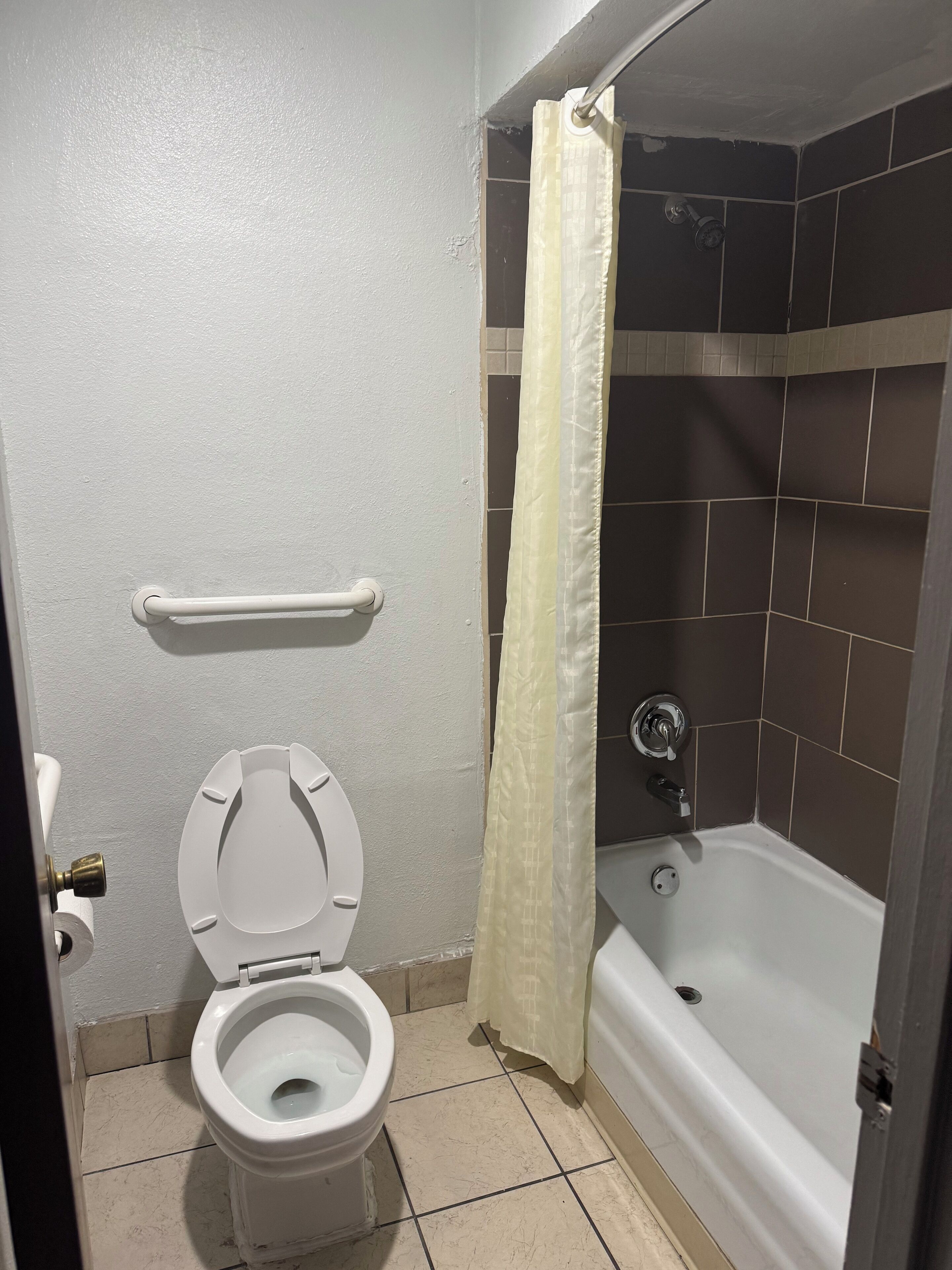 Ein Badezimmer mit Toilette, einer Duschkabine und einer Badewanne.
