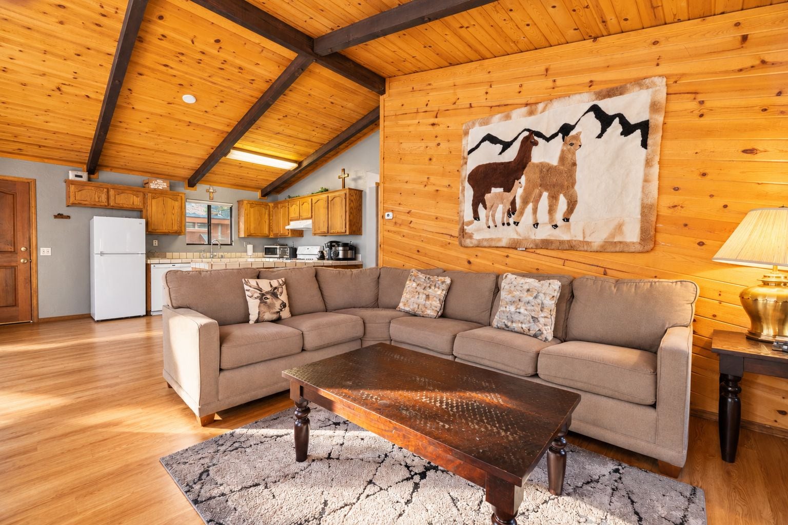A cozy living room with a sectional sofa, a wooden coffee table, and a rug.