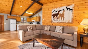A cozy living room with a sectional sofa, a wooden coffee table, and a rug.