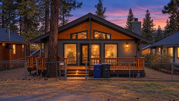 A modern two-story lodge with a wooden exterior, large windows, and a porch with a railing. - The Great Escape (Big Bear City)