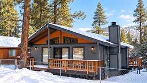 A cabin with a wooden deck, large windows, and a chimney. - The Great Escape (Big Bear City)
