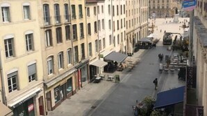 A street view with buildings, outdoor seating, and a clear sky. - Hotel Les Portes D'Or (Nancy)