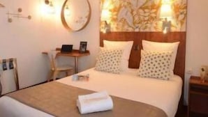 A hotel room with a bed, a desk, and a chair. - Hotel Les Portes D'Or (Nancy)