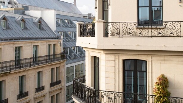 A multi-story building with a balcony, large windows, and a metal roof. - The (Courdemanche)