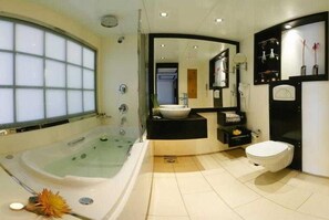 Une salle de bain moderne avec une baignoire sur pieds, des toilettes et un lavabo.