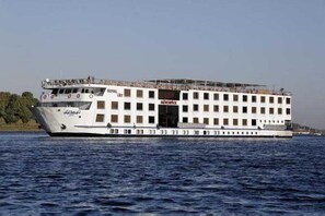 Un grand bateau fluvial à plusieurs ponts, baptisé « ROYAL LILY », était amarré à un quai.