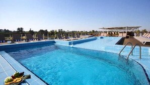 A swimming pool with lounge chairs and a covered area. - Movenpick MS Royal Lily Nile Cruise (Luxor)