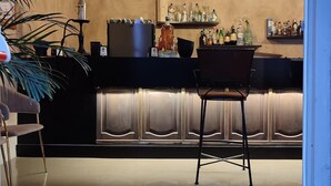 A bar area with a polished concrete floor, a bar counter with a variety of bottles, and two pendant lights. - TERRACQUA--an oasis of peace in the Tuscan hills (Chiusi)