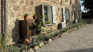 A rustic stone building with a gravel driveway and potted plants. - TERRACQUA--an oasis of peace in the Tuscan hills (Chiusi)