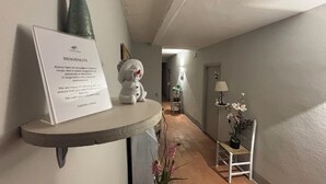 A hallway with a welcome sign, a small white figurine, a potted plant, and a lamp. - TERRACQUA--an oasis of peace in the Tuscan hills (Chiusi)