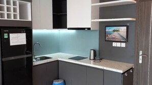 A compact kitchen with a refrigerator, sink, and a small countertop. - Premium CSJ Apartment - Nice View and Walk To Vung Tau Beach (Vũng Tàu)