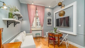 A dining area with a round table, chairs, and a window with curtains.