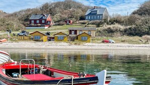 A row of boats docked at a calm waterfront with houses in the background. - 4 Star Holiday Home in Allinge (Allinge)