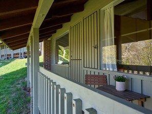 A covered porch with a wooden bench and potted plants. - 4 Star Holiday Home in Allinge (Allinge)