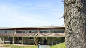 A building with a covered patio area, numbered rooms, and a sign indicating room numbers. - 4 Star Holiday Home in Allinge (Allinge)