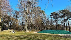 A park with a picnic table, a playground, and a green tent. - 4 Star Holiday Home in Allinge (Allinge)