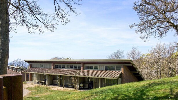 A two-story building with a covered patio area, a brick exterior, and a grassy landscape. - 4 Star Holiday Home in Allinge (Allinge)