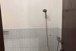 A shower with a handheld showerhead and a wall-mounted faucet. - Taman Ayu Homestay Munduk Mitra RedDoorz (Bali)