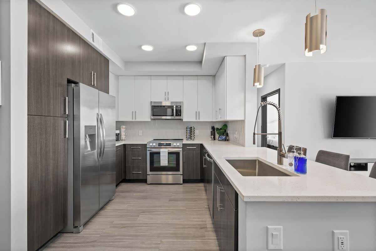 Una cocina moderna con electrodomésticos de acero inoxidable, armarios blancos y una isla grande.