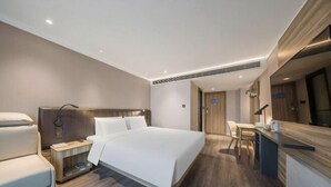 A modern hotel room with a large bed, bedside tables, a desk, and a chair. - HanTing Premium Hotel (Beijing Jinsong Subway Station) (Beijing)