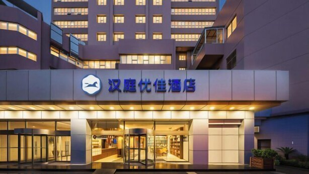 A hotel entrance with a modern design, featuring a prominent sign and a glass door entrance. - HanTing Premium Hotel (Beijing Jinsong Subway Station) (Beijing)