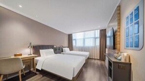 A hotel room with two beds, a desk, a chair, a TV, and a fireplace. - HanTing Premium Hotel (Beijing Jinsong Subway Station) (Beijing)
