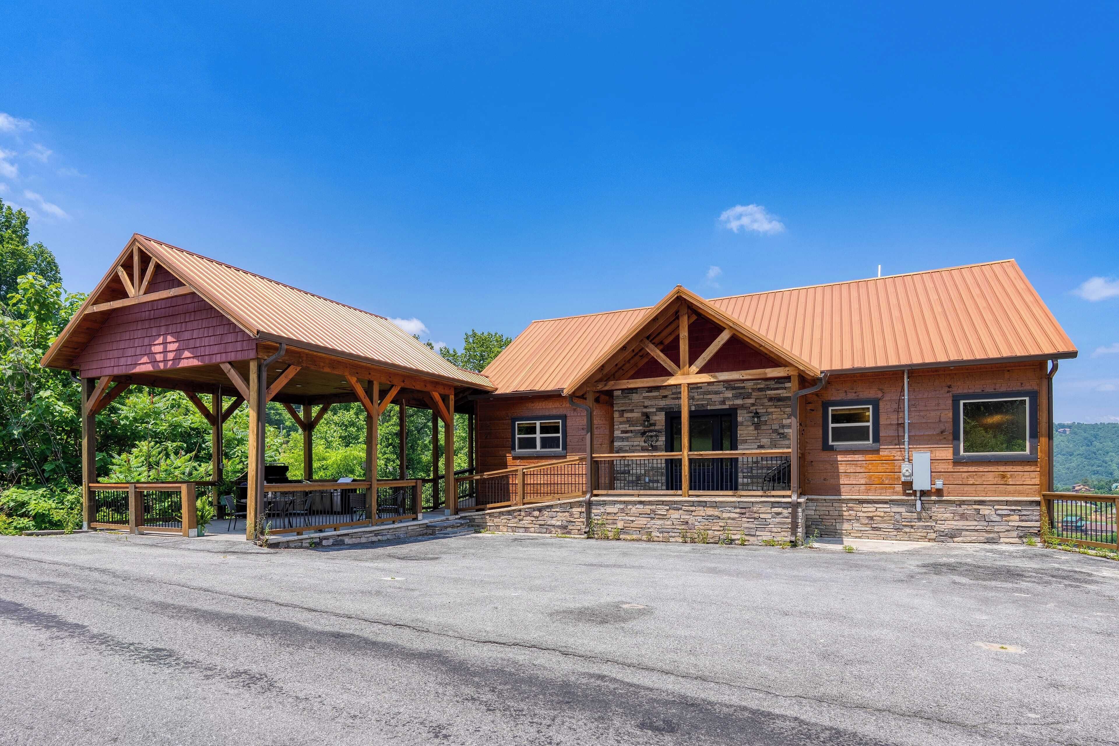 A lodge with a covered porch, stone foundation, and a metal roof.