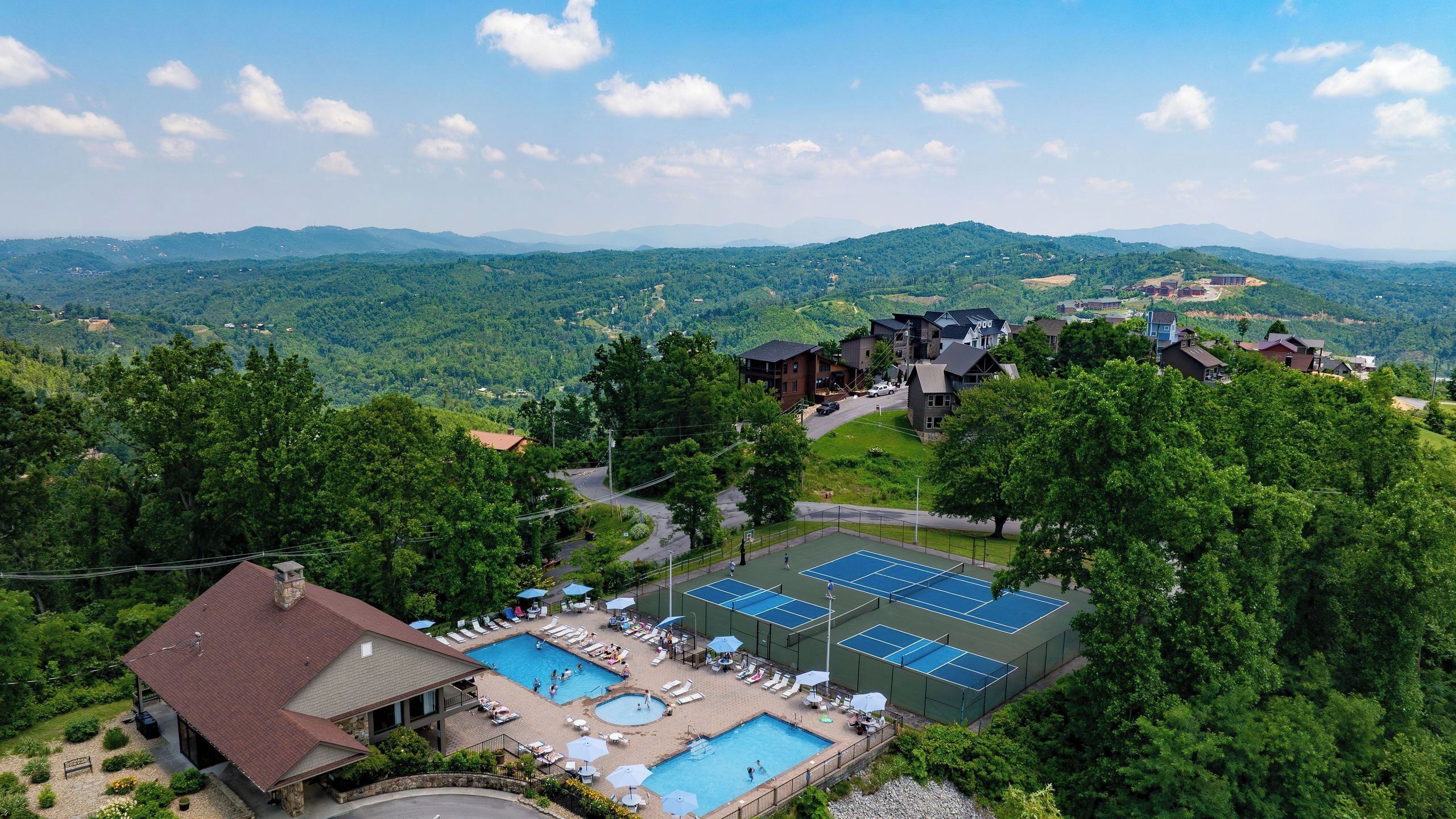 Un complexe hôtelier doté d’une piscine, de courts de tennis et offrant une vue sur les montagnes environnantes.