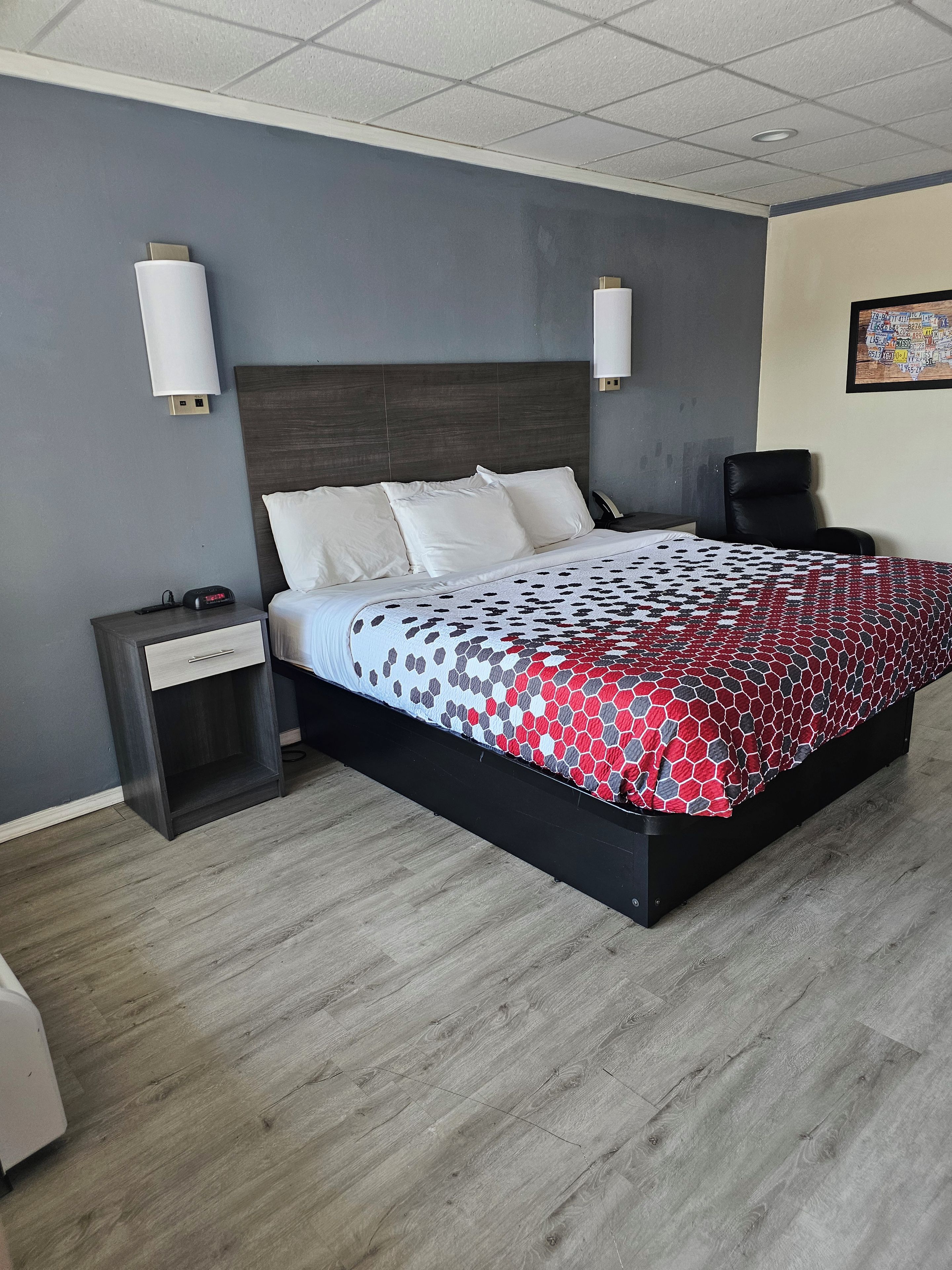 Une chambre d’hôtel moderne, dotée d’un grand lit, d’une table de chevet, d’un bureau et d’une chaise.