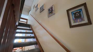 Een trap met houten leuningen en een muur met ingelijste foto's.