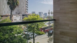 A view from a window overlooking a street with cars, a bus, and buildings. - Artline by Wynwood House (Lima)