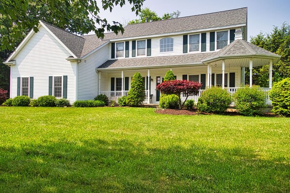 A two-story house with a front porch, a covered entryway, and a well-maintained lawn.