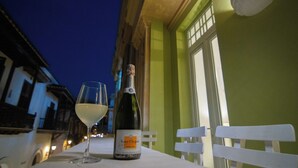 Een fles champagne en een glas op een tafel voor een gebouw, 's nachts.