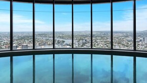 Une vue panoramique depuis un immeuble de grande hauteur, doté de grandes fenêtres et d’un plancher en verre.