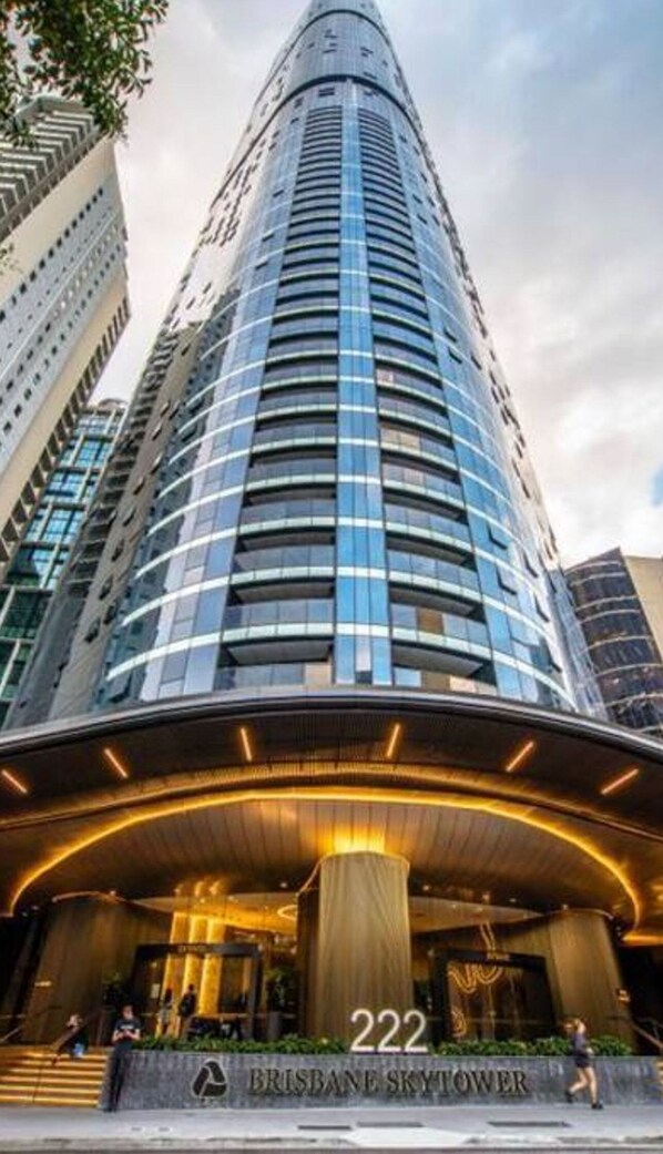 A tall, modern skyscraper with a curved facade and a prominent entrance labeled "222 Brisbane Skytower". - 2BR Luxury Skytower CBD Pool Gym Netflix (Brisbane)