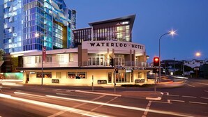 A hotel with a modern design, located at a city intersection. - 2BR Food Drink Hub Pool Views Gym Roof Tce (Brisbane)