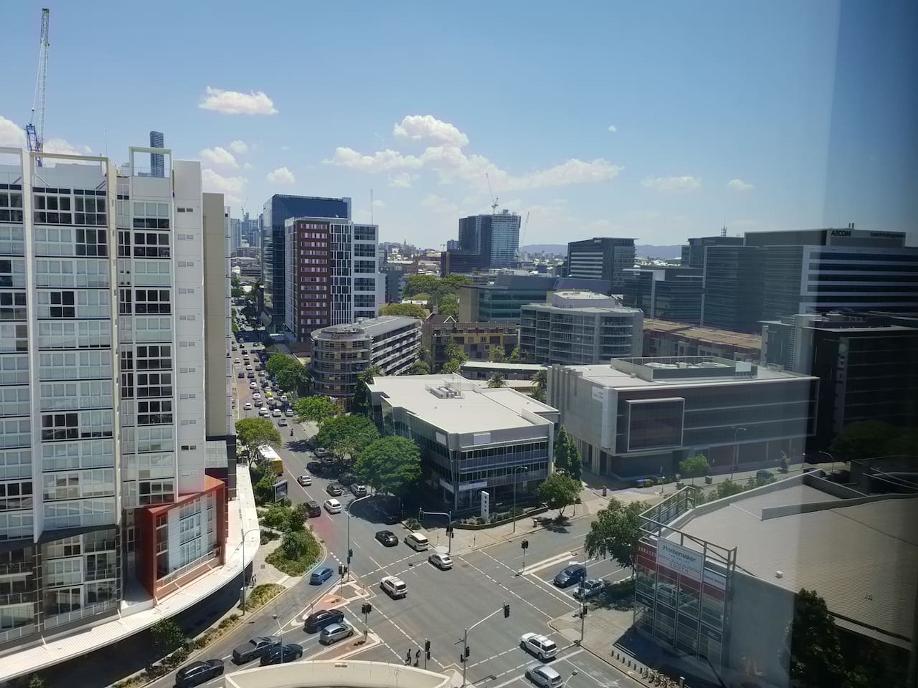 A cityscape with modern buildings, a busy intersection, and clear skies.