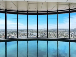 Panoramisch uitzicht vanaf een hoog gebouw met grote ramen en een glazen vloer.