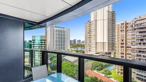 A modern apartment with a balcony, large windows, and a view of surrounding high-rise buildings. - 2BR Luxury Skytower Views CBD Pool Gym Netflix (Brisbane)