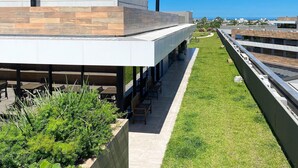 Un edificio moderno con techo plano, zona de estar al aire libre y vistas a la ciudad.