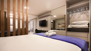 Una habitación de hotel moderna con una cama grande, un televisor de pantalla plana, un armario con espacio para colgar y un espejo.