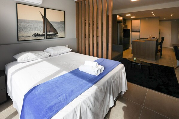 Una habitación de hotel con una cama, un escritorio y vista al mar.