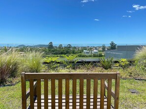 Un banco de madera con vistas a una zona residencial y una masa de agua al fondo.