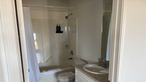 A bathroom with a bathtub, toilet, and sink. - Candle Lake Golf Course - Spruce Cabin (Candle Lake)
