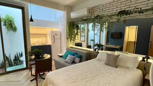 Ein modernes Schlafzimmer mit einem großen Bett, einem Schreibtisch und einem Essbereich.