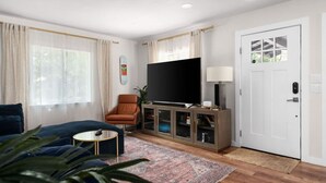 Ein modernes Wohnzimmer mit einer Couch, einem Sessel, einem Fernseher und einer Vitrine.
